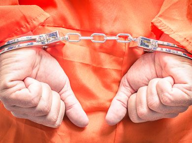 man in orange prison suit and handcuffed behind his back